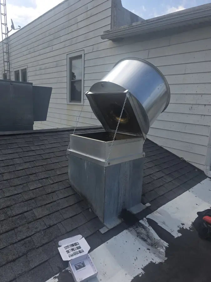 Hinge kit installed on a rooftop kitchen exhaust fan in northern Illinois