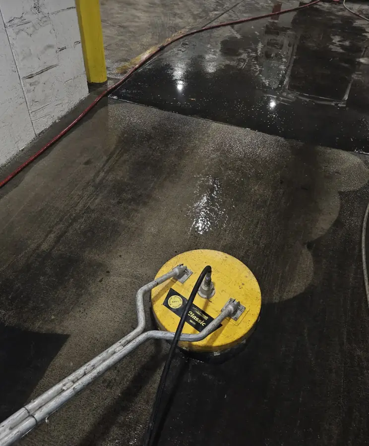 Parking garage concrete cleaned with a surface cleaner, before and after line visible